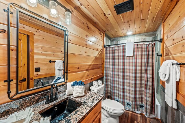 full bathroom with shower / bathtub combination with curtain, wood ceiling, vanity, toilet, and wood walls