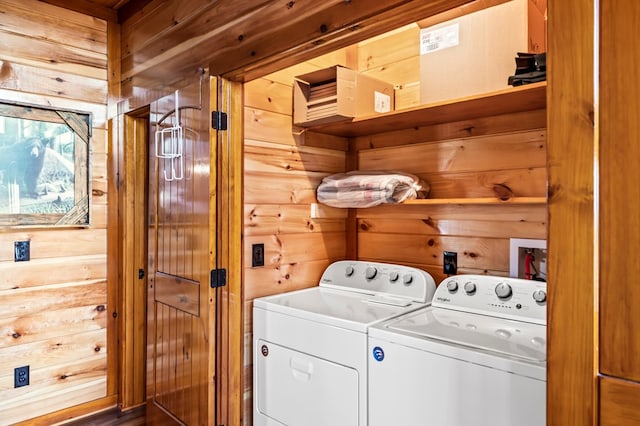 washroom with washer and clothes dryer and wood walls