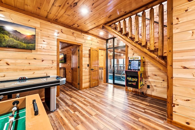 game room with wooden walls, wooden ceiling, and wood-type flooring