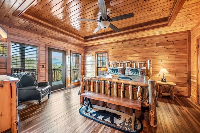 bedroom with ceiling fan, wooden walls, access to outside, and wood ceiling