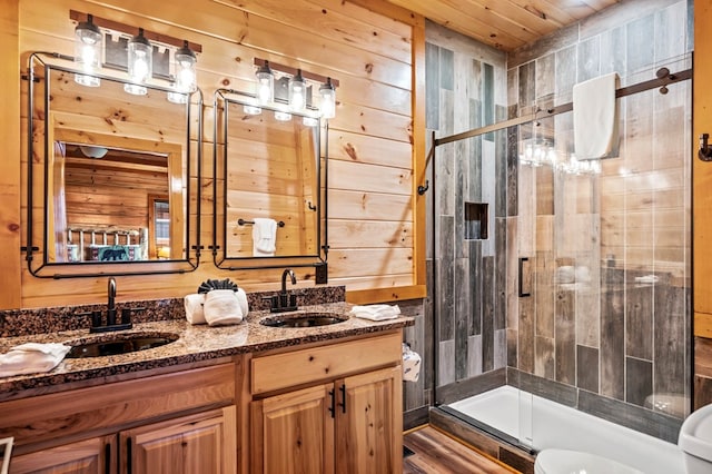 bathroom with walk in shower, vanity, and wooden walls