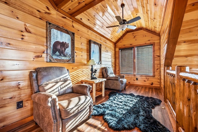 living area with lofted ceiling, hardwood / wood-style flooring, ceiling fan, wooden walls, and wooden ceiling