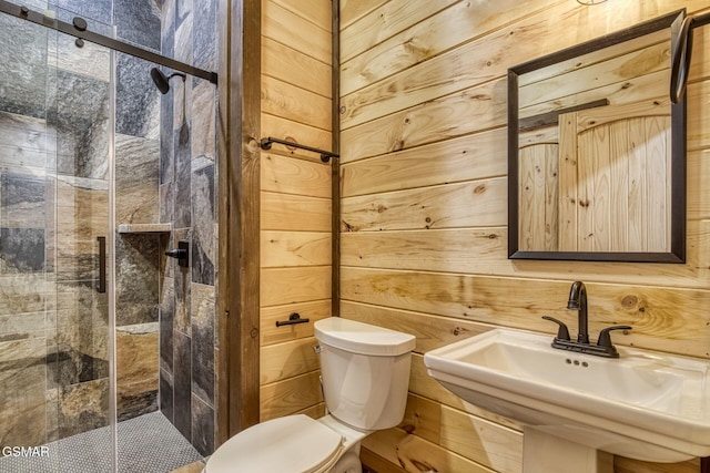 full bathroom with toilet, a sink, a stall shower, and wooden walls