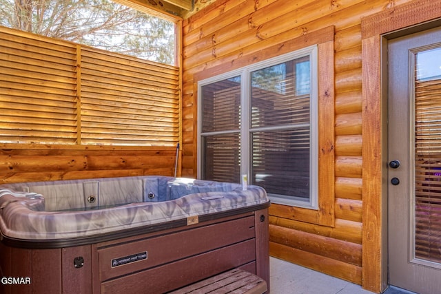 bedroom featuring log walls and multiple windows