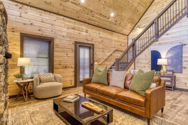 living area featuring wood walls, wood ceiling, stairs, vaulted ceiling, and wood finished floors