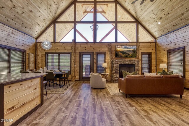 living room with high vaulted ceiling, wood finished floors, wooden walls, and wood ceiling