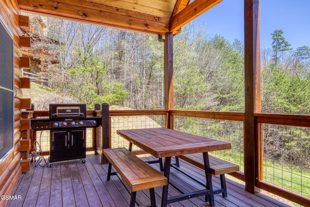 wooden terrace with outdoor dining space and grilling area