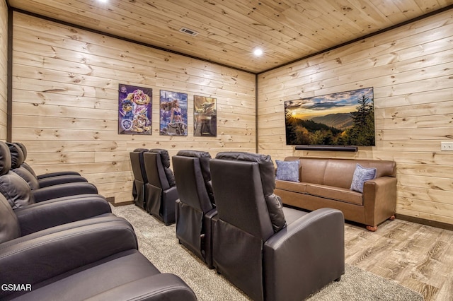 cinema room with wooden walls, wooden ceiling, recessed lighting, light wood-style floors, and baseboards
