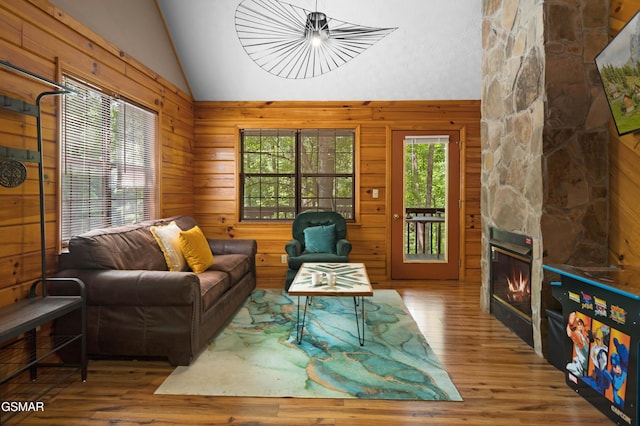 1503 Squirrel Nest Way, Sevierville, TN 37876 - living room featuring lofted ceiling, wood finished floors, wooden walls, and a stone fireplace