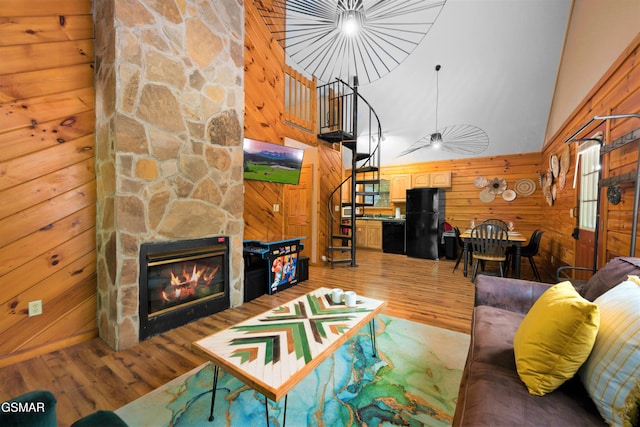 1503 Squirrel Nest Way, Sevierville, TN 37876 - living area featuring wooden walls, wood finished floors, stairway, a stone fireplace, and high vaulted ceiling