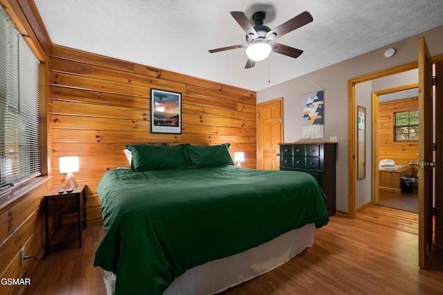 1503 Squirrel Nest Way, Sevierville, TN 37876 - bedroom with wooden walls, wood finished floors, baseboards, a textured ceiling, and a ceiling fan