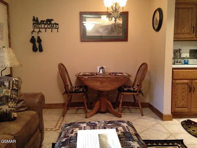 dining room with an inviting chandelier, light tile patterned floors, and baseboards