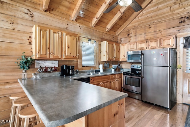 kitchen featuring appliances with stainless steel finishes, sink, a kitchen bar, and kitchen peninsula