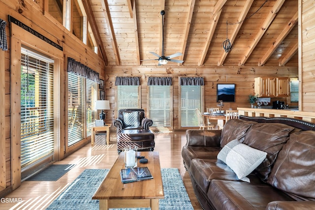 living room with beamed ceiling, light hardwood / wood-style floors, and wood walls