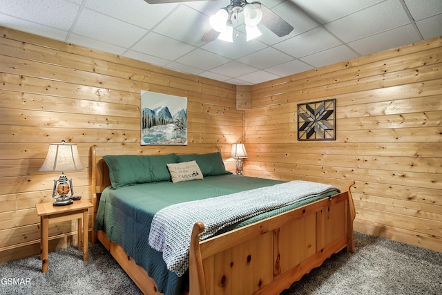 carpeted bedroom with a drop ceiling and ceiling fan