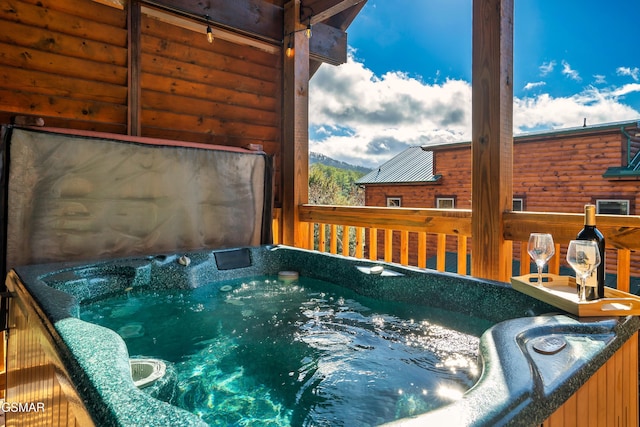 view of swimming pool featuring a hot tub and a deck