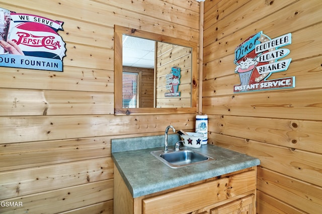 bathroom featuring vanity and wooden walls