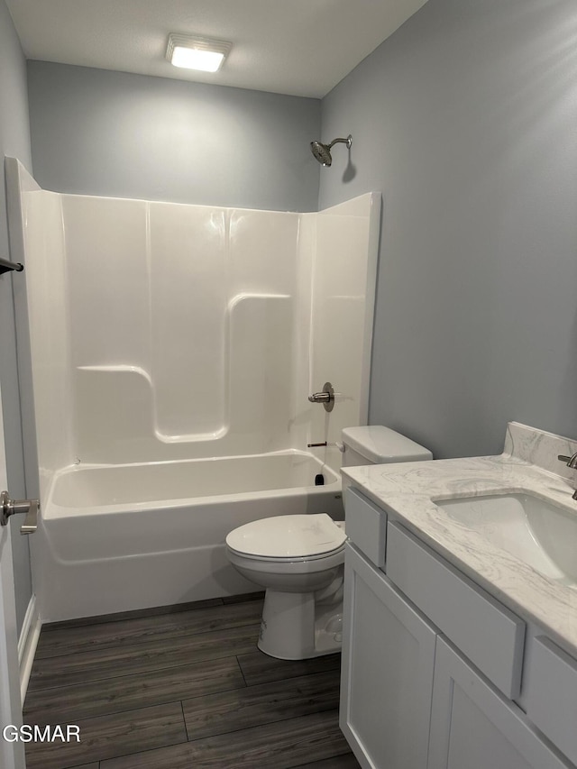 full bath with tub / shower combination, wood finished floors, toilet, and vanity
