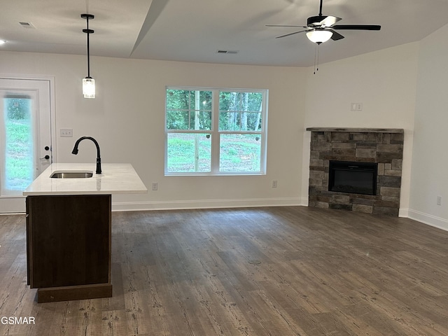 unfurnished living room with visible vents, a sink, dark wood-style flooring, and a ceiling fan