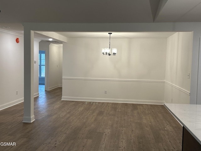 unfurnished dining area with an inviting chandelier, baseboards, ornamental molding, and dark wood-style floors