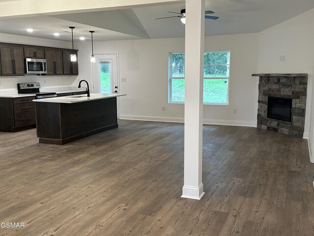 kitchen featuring dark wood-style flooring, open floor plan, appliances with stainless steel finishes, and a sink