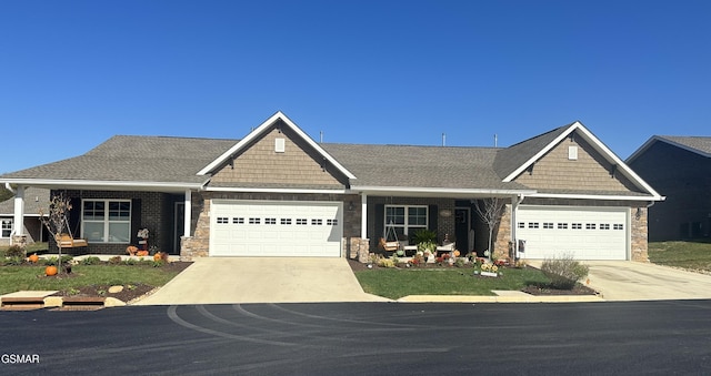 craftsman-style house featuring concrete driveway, brick siding, a front yard, and a garage