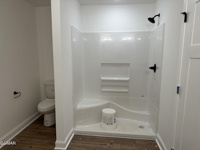 full bathroom with a shower, baseboards, wood finished floors, and toilet