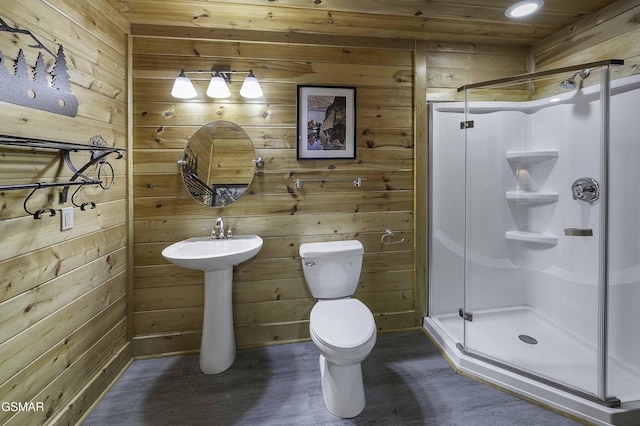 bathroom with wood walls, toilet, and walk in shower