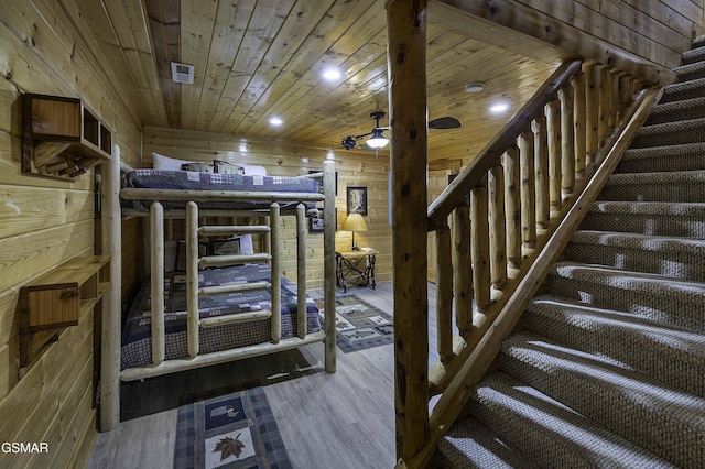 stairs with hardwood / wood-style floors, wood ceiling, and wood walls