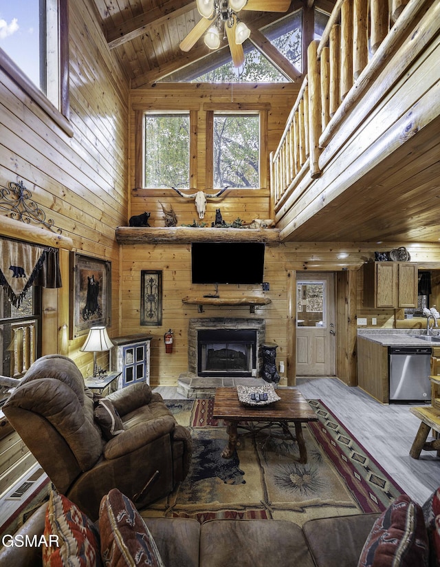 living room with wooden walls, a healthy amount of sunlight, and wood ceiling