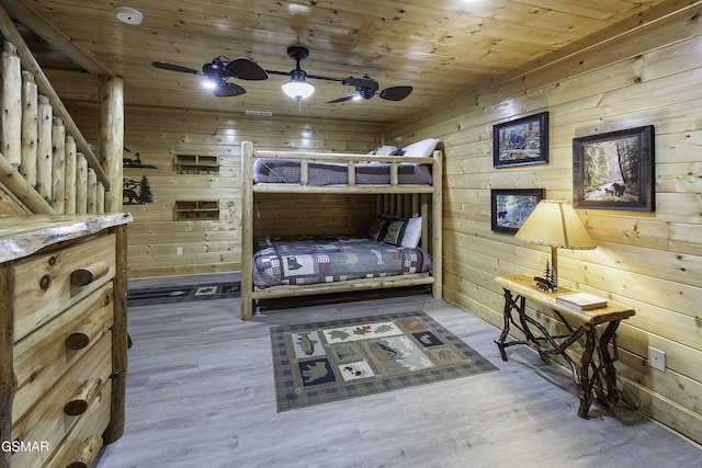 bedroom featuring hardwood / wood-style floors, ceiling fan, wood walls, and wood ceiling