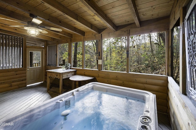 interior space with wood ceiling, beamed ceiling, a healthy amount of sunlight, and a hot tub