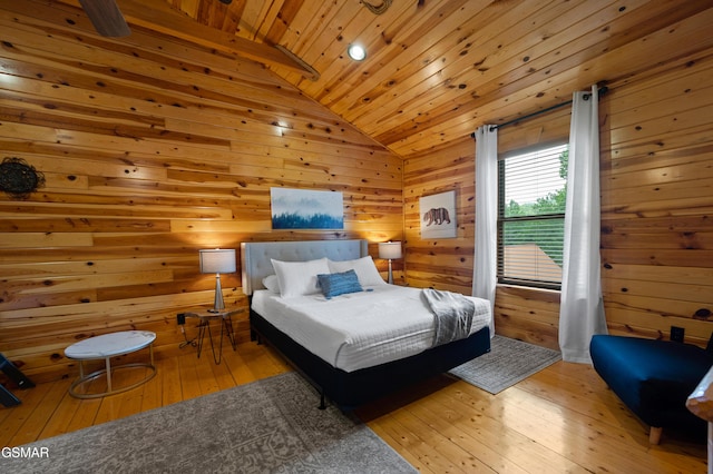 bedroom featuring vaulted ceiling, light hardwood / wood-style flooring, wood ceiling, and wood walls