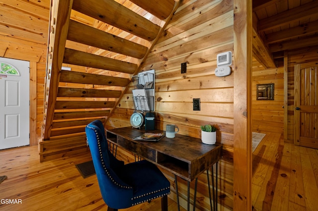 dining space featuring hardwood / wood-style floors, lofted ceiling with beams, wood walls, and wood ceiling