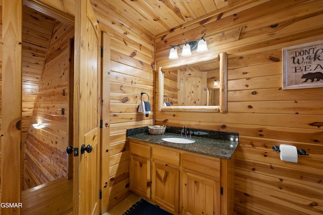 bathroom with vanity, wood ceiling, and wooden walls