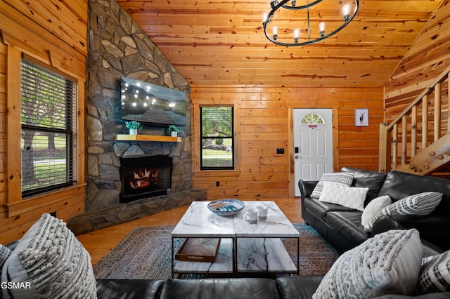 living room with hardwood / wood-style floors, wooden ceiling, high vaulted ceiling, a stone fireplace, and wooden walls