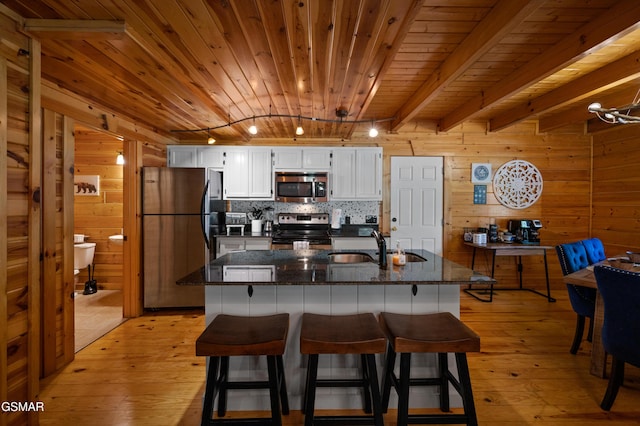 kitchen featuring track lighting, wood ceiling, stainless steel appliances, sink, and white cabinets