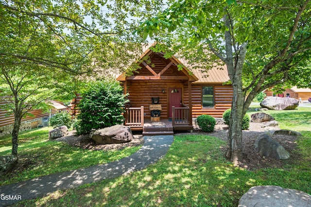 log home with a wooden deck and a front lawn