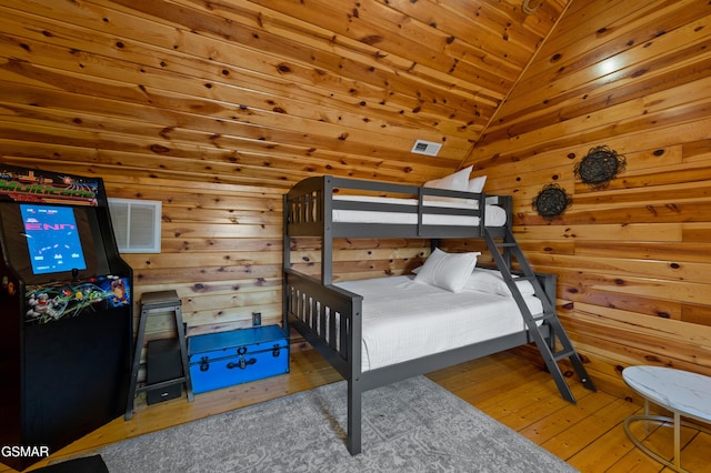 bedroom with hardwood / wood-style floors, wooden ceiling, lofted ceiling, and wood walls