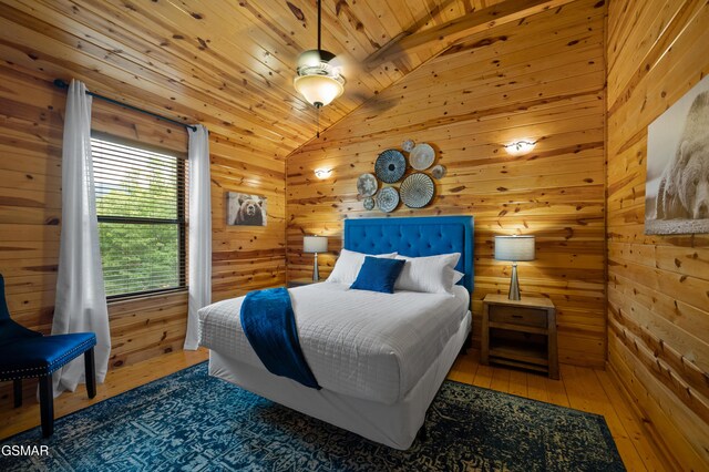 bedroom featuring wood walls, lofted ceiling, dark hardwood / wood-style floors, ceiling fan, and wood ceiling