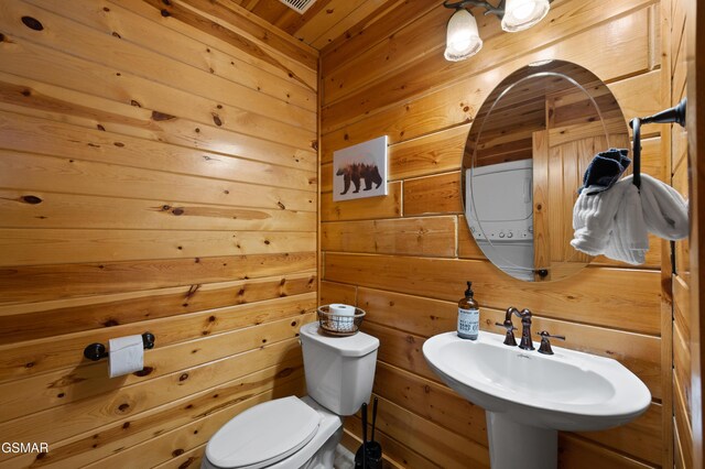 bathroom with wooden walls, sink, wood ceiling, and toilet