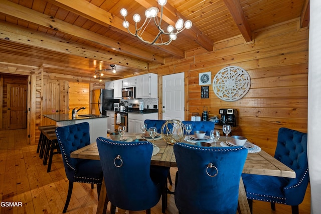 dining area featuring wooden ceiling, sink, beamed ceiling, a notable chandelier, and light hardwood / wood-style floors