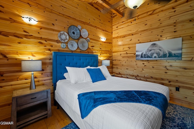 bedroom featuring wooden walls, beamed ceiling, and wood-type flooring