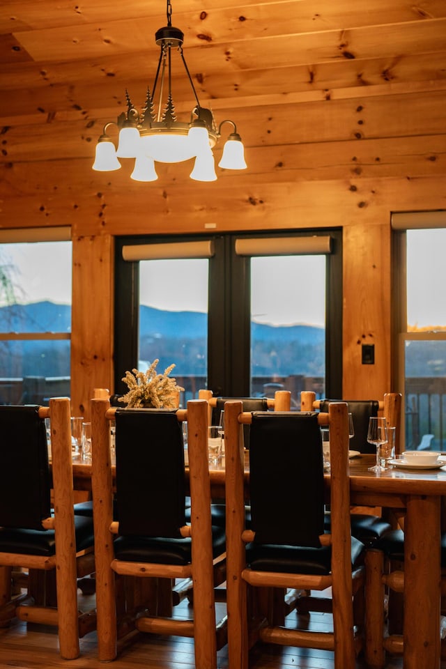 dining room with a healthy amount of sunlight, a chandelier, and wood finished floors