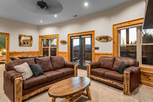 carpeted living area featuring recessed lighting, plenty of natural light, and wainscoting