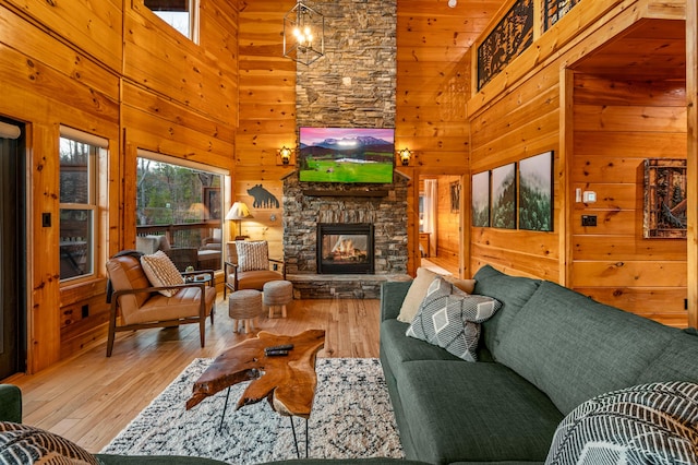 living room with a fireplace, wooden walls, and hardwood / wood-style flooring