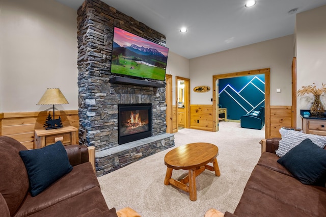 living area with a wainscoted wall, carpet flooring, wood walls, a fireplace, and recessed lighting