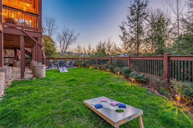 yard at dusk featuring a patio and fence