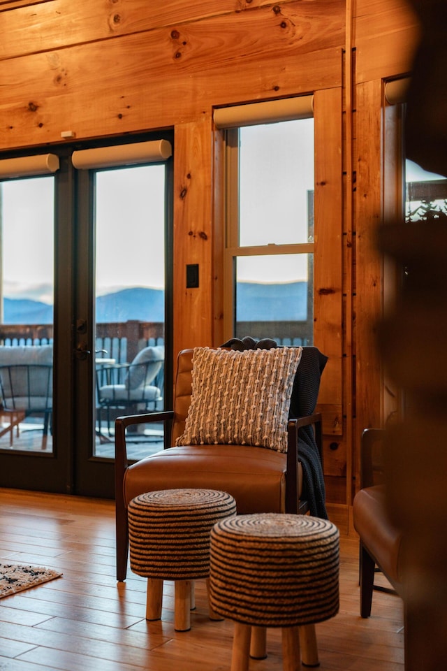 sitting room featuring a healthy amount of sunlight, hardwood / wood-style flooring, and wooden walls