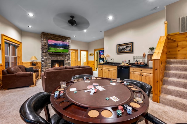 recreation room with carpet floors, recessed lighting, ceiling fan, a stone fireplace, and wet bar